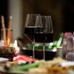 Bicchiere di vino su un tavolo in luce soffusa, simbolo della lotta personale e della ripresa