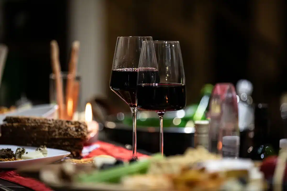 Bicchiere di vino su un tavolo in luce soffusa, simbolo della lotta personale e della ripresa