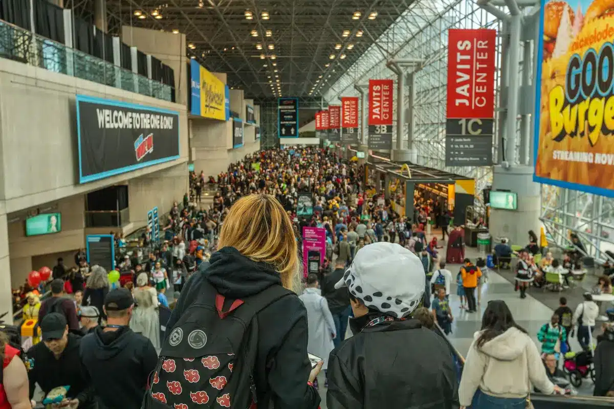 Visitatori di una convention di fumetti ascoltano gli artisti al panel principale