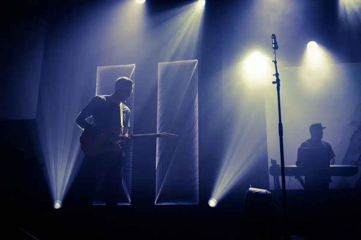 Musicisti che suonano su un palco illuminato durante una performance dal vivo