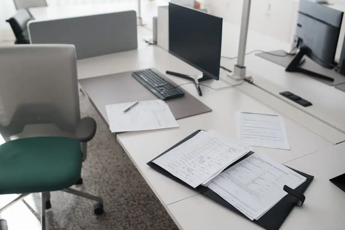 Scrivania di professionista con documenti, laptop e strumenti di lavoro organizzati