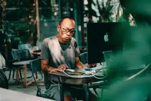 Mano su tastiera Mac con icona microfono luminosa e finestre di documenti sullo sfondo