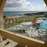 Elegante hall d'albergo con dettagli art déco, arredi d'epoca e illuminazione che crea ombre su marmi e ringhiere orname