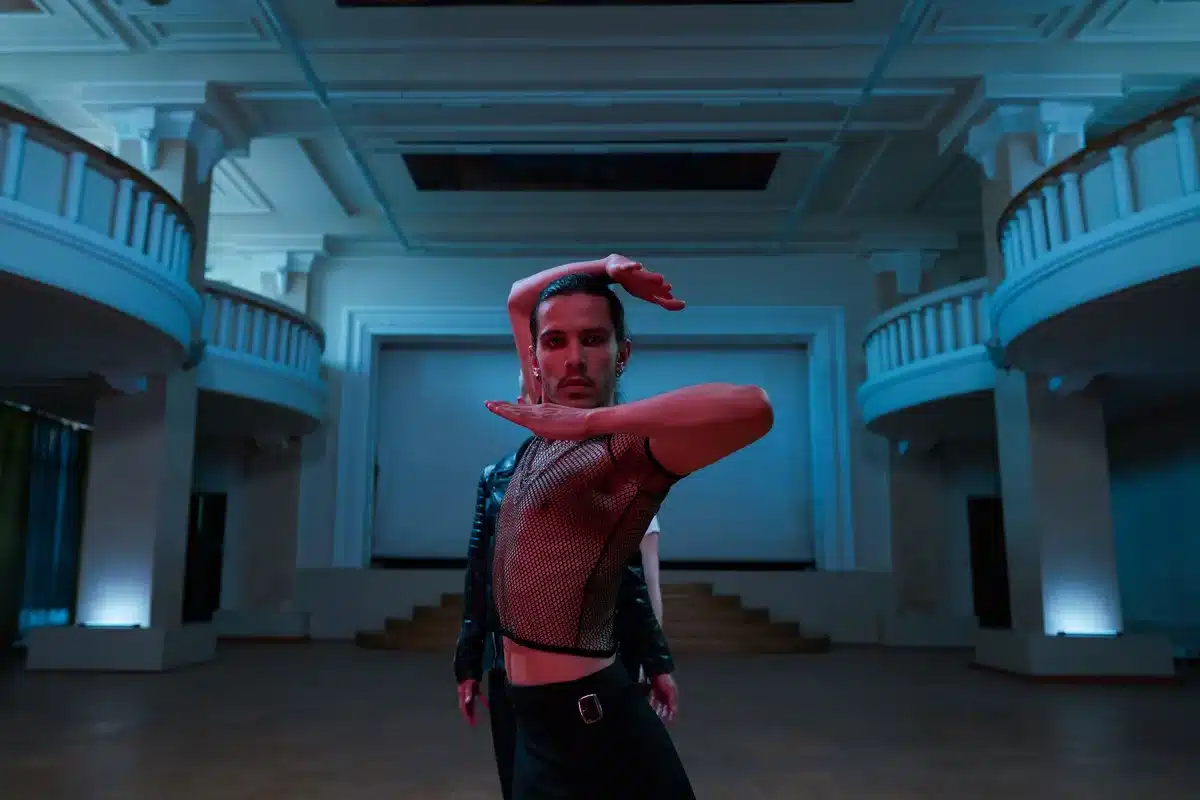 Interno di un'accademia di danza con architettura drammatica e illuminazione cromatica intensa