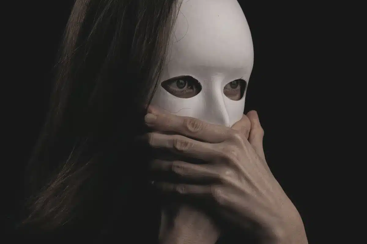 Figura femminile con maschera o volto celato, simbolo di identità nascosta
