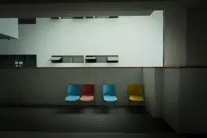 Persona seduta in sala d'attesa per un provino, mani tese, espressione nervosa