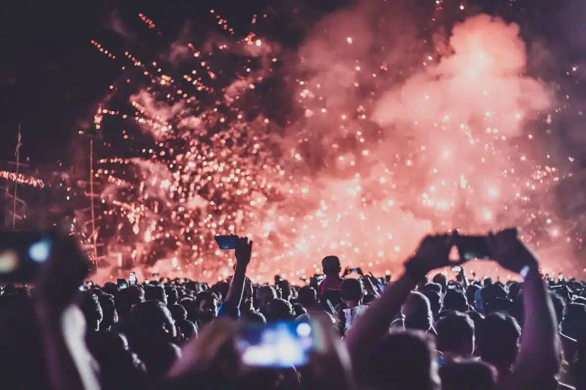 Folla di spettatori con le mani alzate durante un concerto in una venue all'aperto sul mare di sera