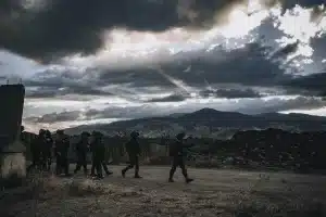 Soldati in un canyon desertico durante un'imboscata, circondati da fumo e polvere