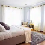 Letto che sembra un acquario con due silhouette lontane, luce calda e riflessi