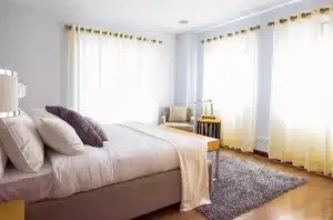 Letto che sembra un acquario con due silhouette lontane, luce calda e riflessi