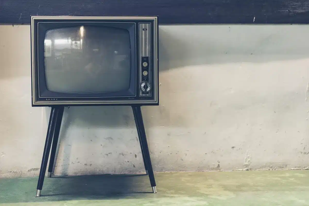 Televisione d'epoca e poster vintage in una camera da letto