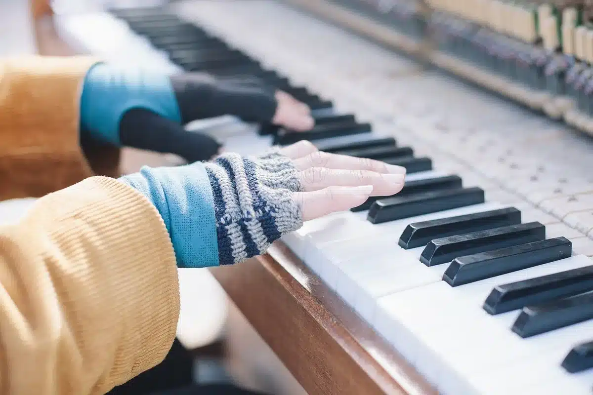 Mani di un pianista che suonano il pianoforte in primo piano