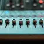 Produttore musicale al lavoro in studio di registrazione con mixer e attrezzature professionali