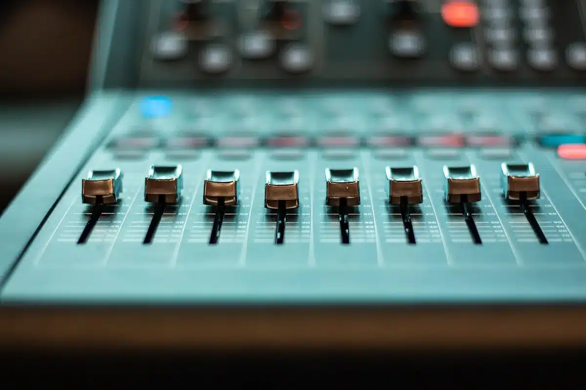 Produttore musicale al lavoro in studio di registrazione con mixer e attrezzature professionali