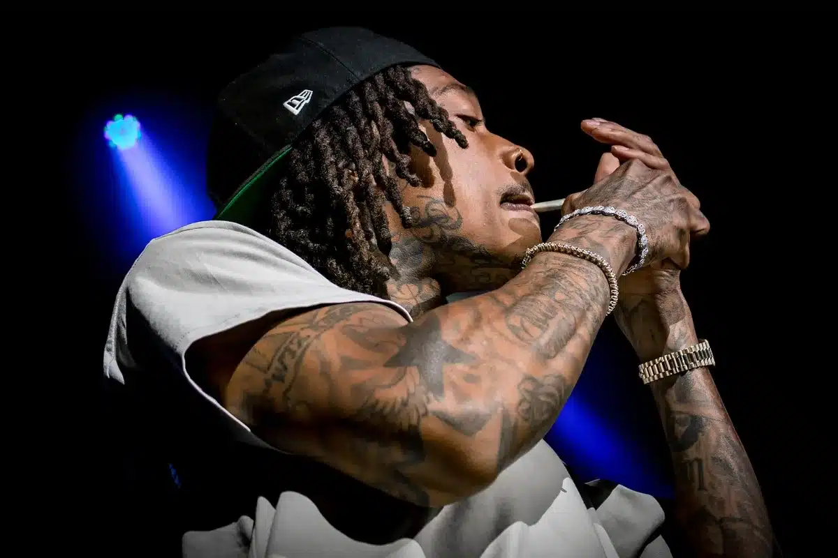 Performer su palco durante una competizione di battle rap con pubblico sullo sfondo