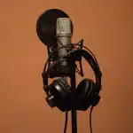Studio di registrazione con microfono e attrezzatura audio in luce soffusa, atmosfera intima e riflessiva
