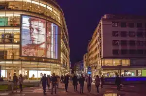 Berlina compatta ibrida parcheggiata in strada urbana con traffico sullo sfondo