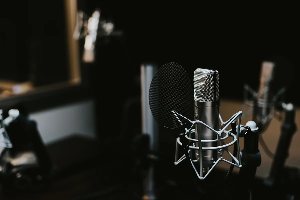 Studio di produzione con attrezzatura audio e strumenti musicali per la creazione di trap e corridos