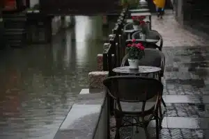 Strada bagnata di notte con due sagome distanti sotto la pioggia
