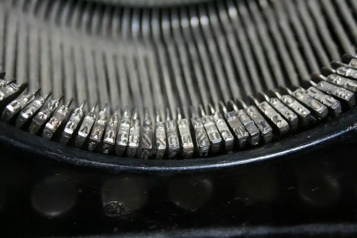 Tavolino con macchina da scrivere, lettere e pagine sparse in luce naturale