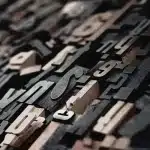 Partecipanti anonimi a un laboratorio con ritagli di pelle e blocchi da stampa su un tavolo