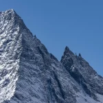Guerriero muscoloso con ascia in paesaggio nordico innevato e montagnoso