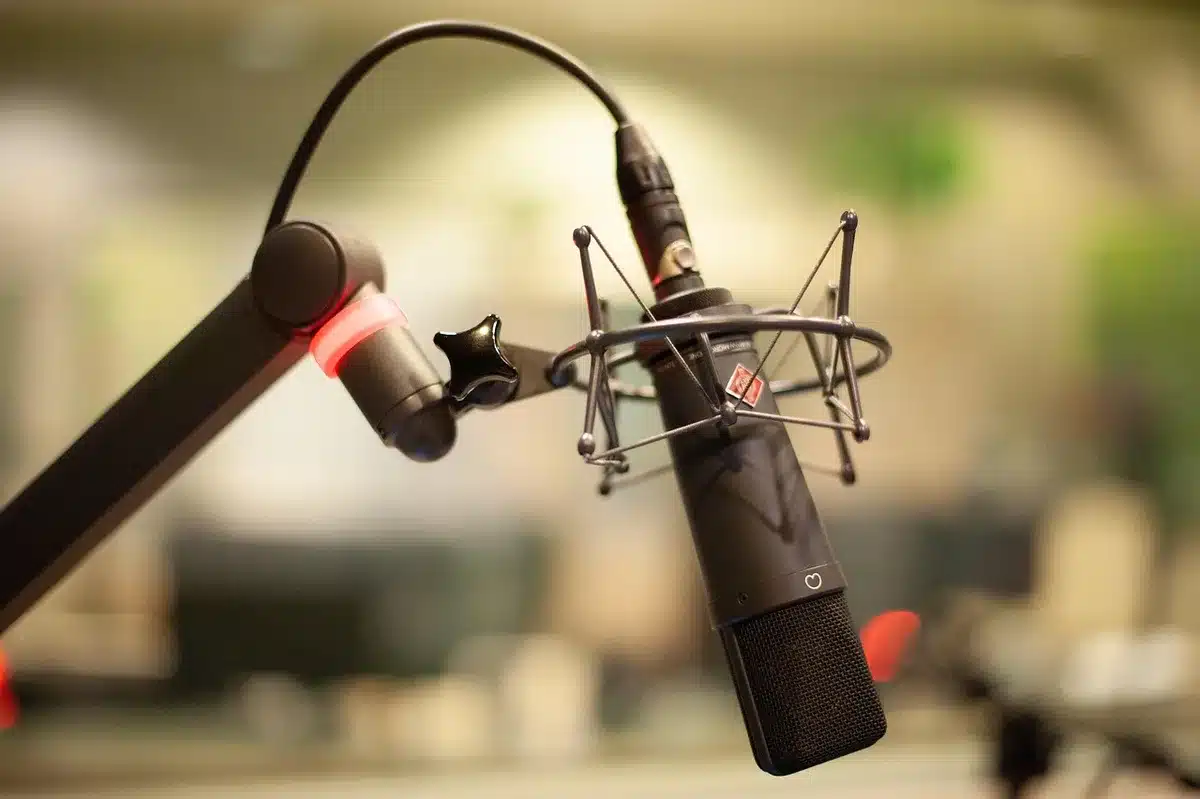 Uomo che parla in un podcast, seduto davanti a un microfono in studio