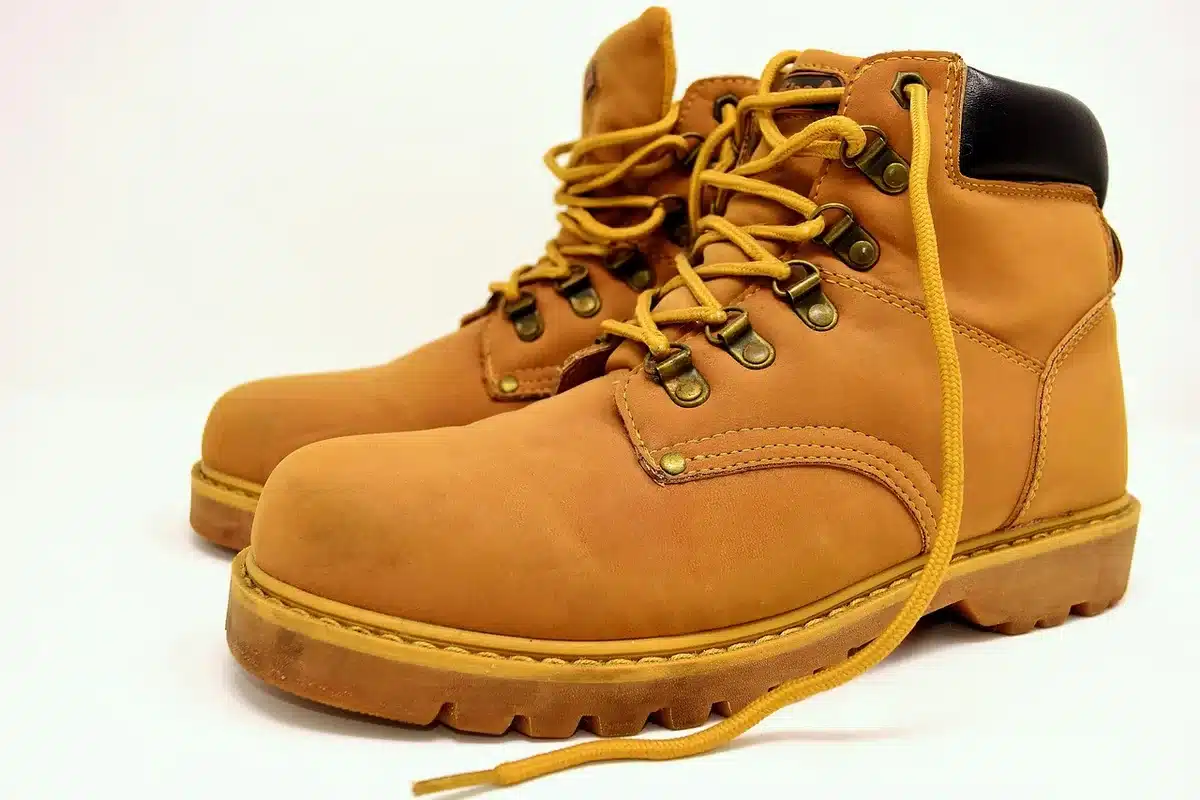 Coppia di scarpe in pelle e tessuto su marciapiede vicino a sentiero, con patina visibile