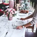 Tavolo da cena con calici e mani anonime visto dall'alto in una sala