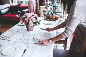 Tavolo da cena con calici e mani anonime visto dall'alto in una sala