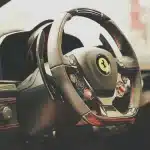 Giacca da corsa rossa con dettagli dorati e stella ricamata, ispirata al patrimonio storico della Scuderia Ferrari