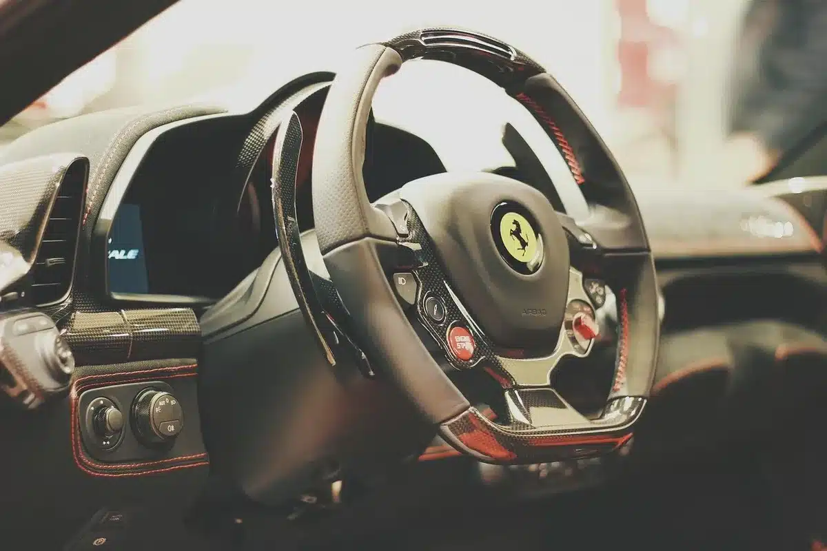 Giacca da corsa rossa con dettagli dorati e stella ricamata, ispirata al patrimonio storico della Scuderia Ferrari