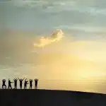 Silhouette di un bus vintage e un appendiabiti con costumi in una strada desertica al tramonto