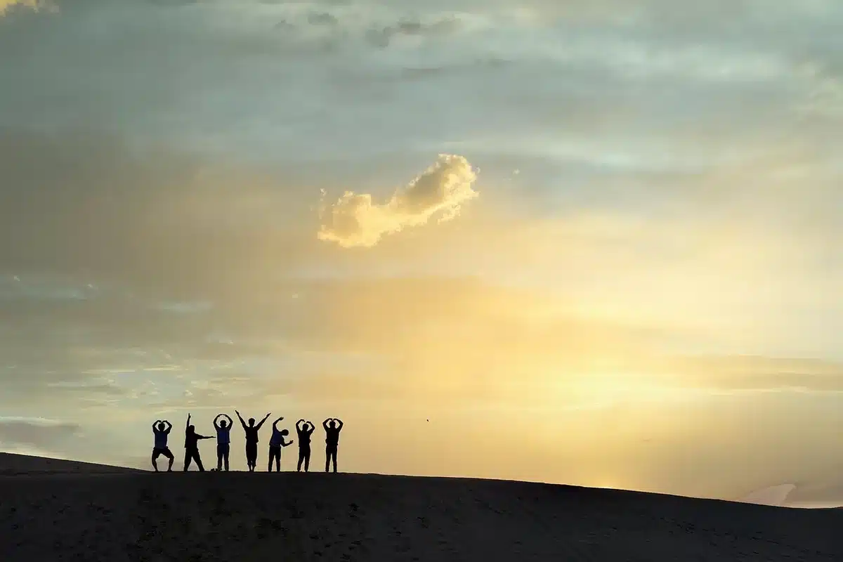Silhouette di un bus vintage e un appendiabiti con costumi in una strada desertica al tramonto