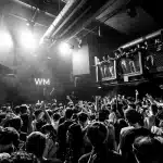 Artista sul palco sotto i riflettori che si connette con il pubblico durante un concerto