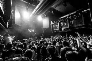 Artista sul palco sotto i riflettori che si connette con il pubblico durante un concerto