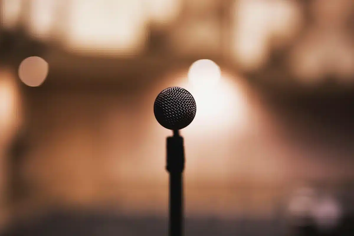 Un attore parla appassionatamente sul palco di una convention davanti al pubblico