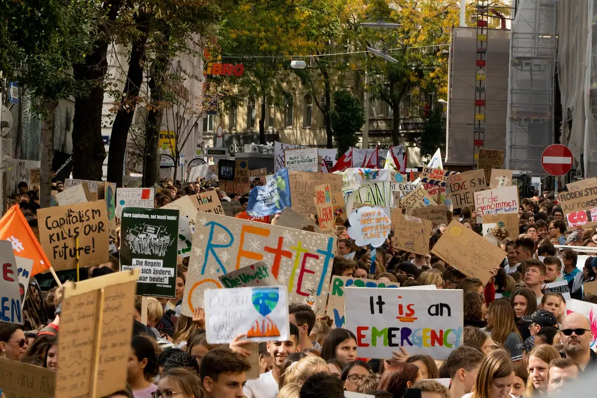 Cartelli urbani e una scia di persone sfocate che suggeriscono critica sociale