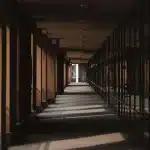 Corridoio dietro le quinte di una cerimonia con statuette e silhouette, illuminazione calda