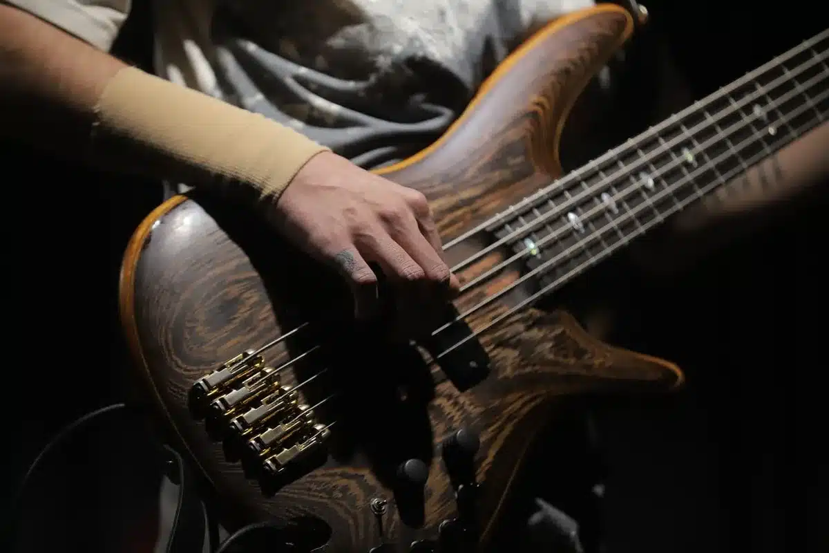 Mano di musicista che tiene una chitarra in studio