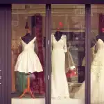 Manichini e capi sartoriali disarticolati esposti in una sala minimal