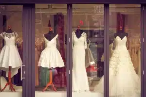 Manichini e capi sartoriali disarticolati esposti in una sala minimal