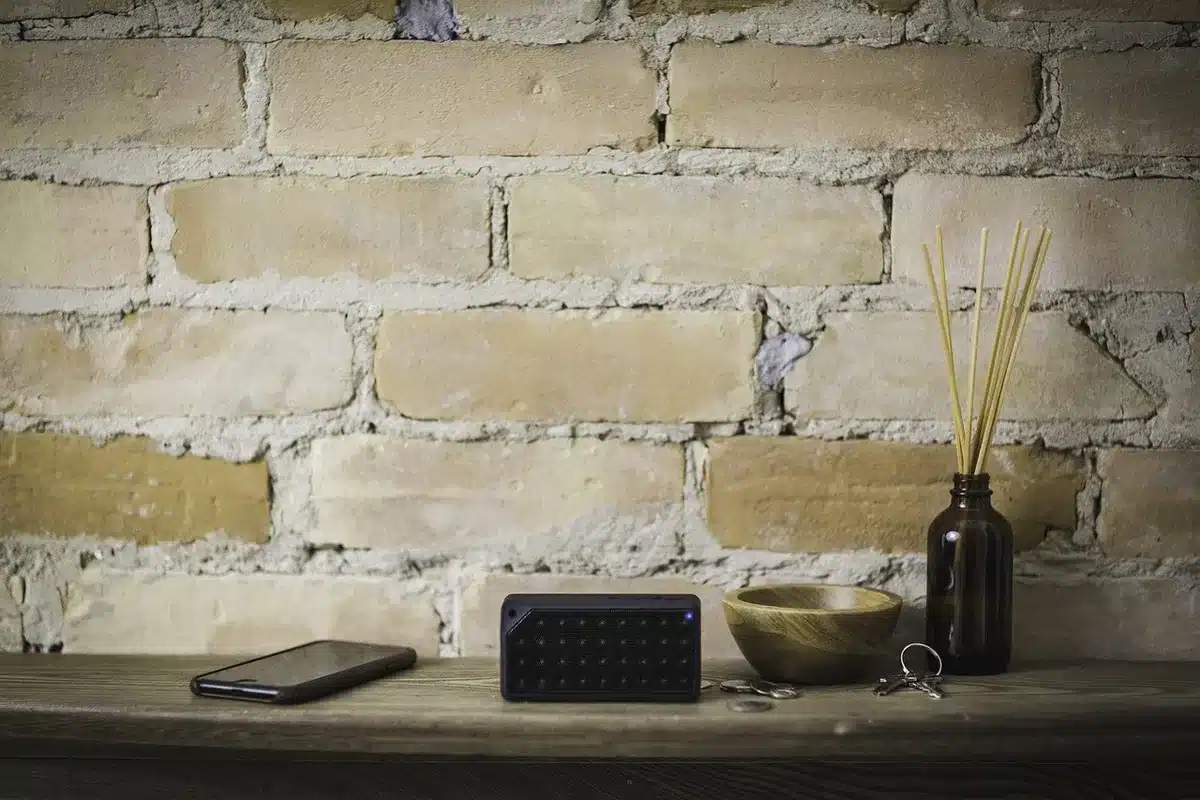 Piccola cassa Bluetooth su tavolo da picnic con moschettone, scena quotidiana all'aperto