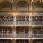 Scaffali di biblioteca e mano anonima che sfoglia un libro, vista ravvicinata