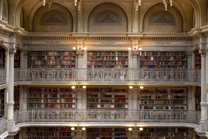 Scaffali di biblioteca e mano anonima che sfoglia un libro, vista ravvicinata