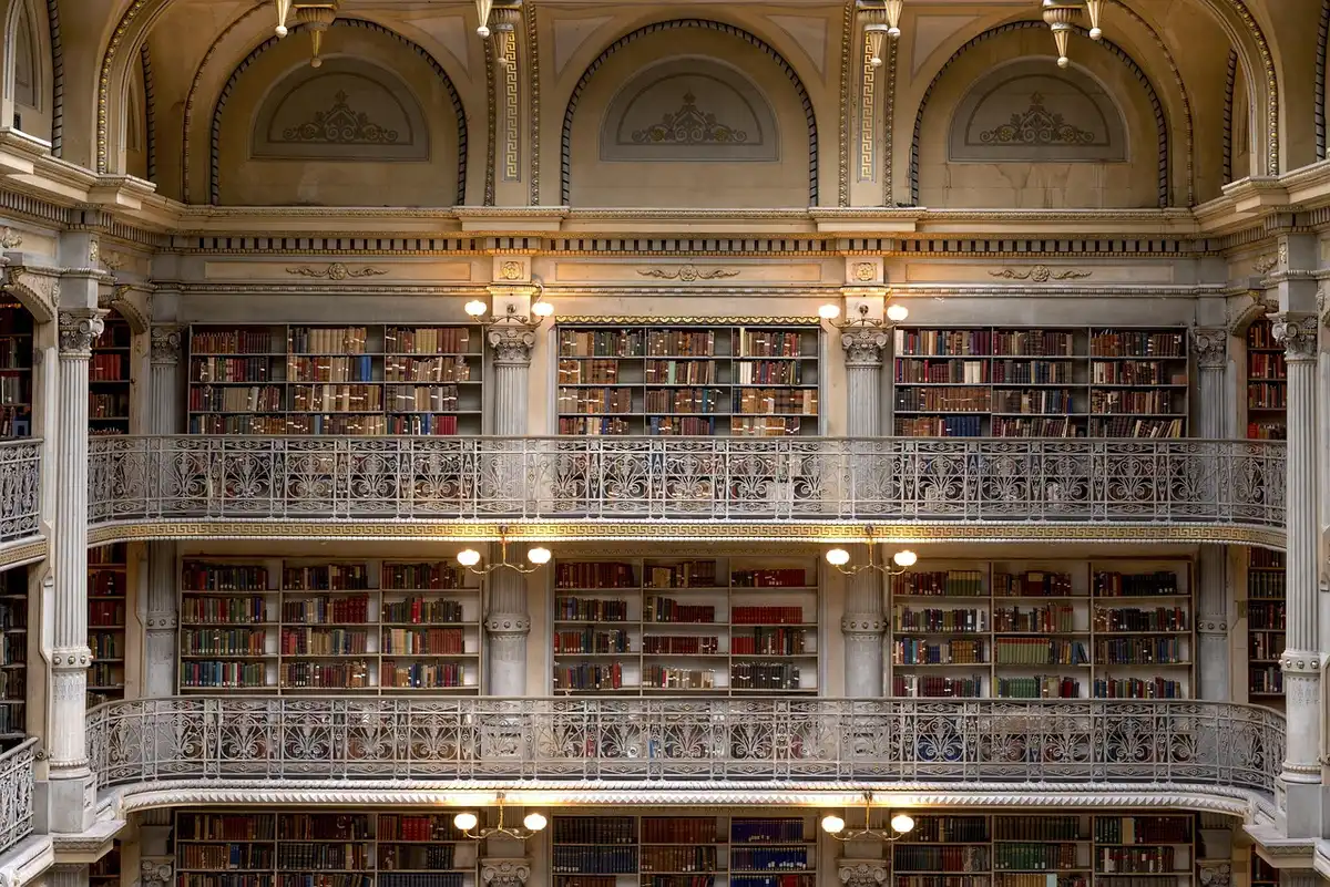 Scaffali di biblioteca e mano anonima che sfoglia un libro, vista ravvicinata