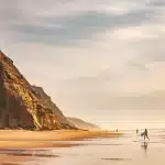 Tavola da surf con scarabocchio calligrafico e pennarello su sabbia