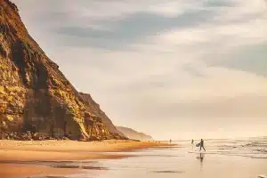 Tavola da surf con scarabocchio calligrafico e pennarello su sabbia