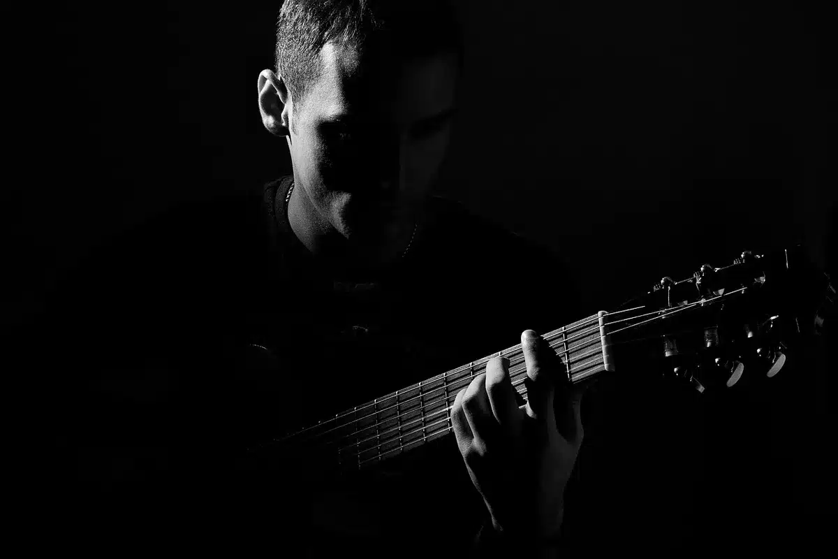 Musicisti in studio con chitarra e cuffie durante una registrazione pop-rock