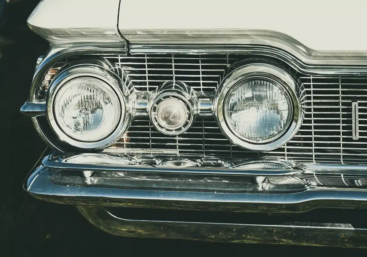 Linee di auto anonime in un capannone, evidenza su fari e pannelli per differenziazione